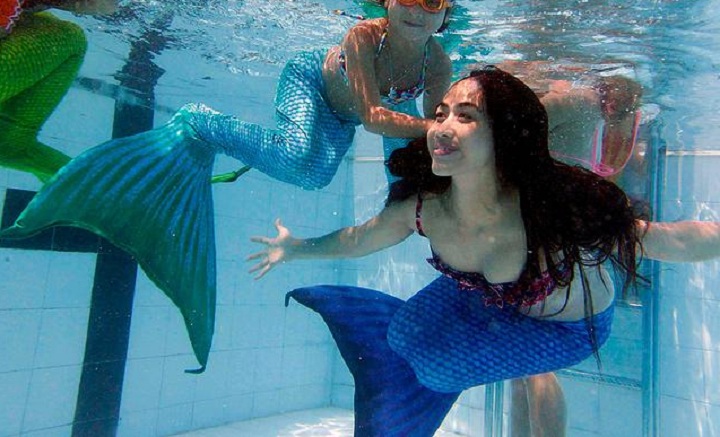 A photo provided by Montreal's AquaMermaid show swimmers wearing the mermaid monofins.