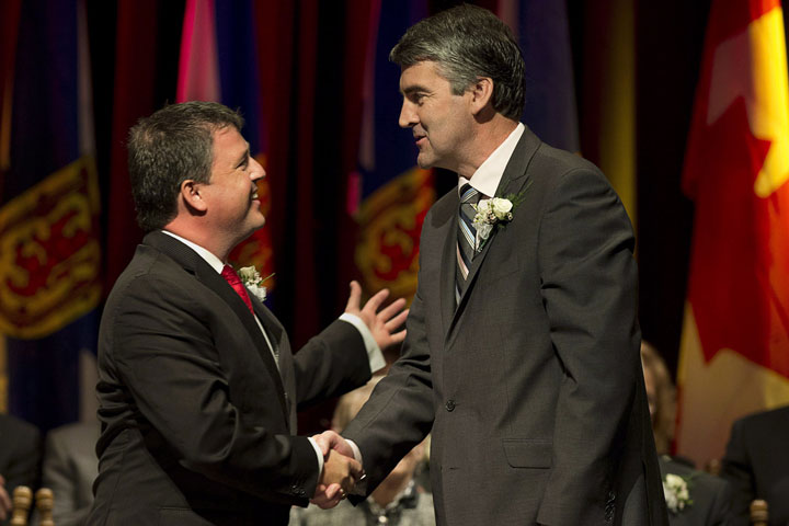 MLA Michel Samson (left) is congratulated by Premier Stephen McNeil, right, as the cabinet is sworn in in Annapolis Royal, N.S., on Oct. 22, 2013. 