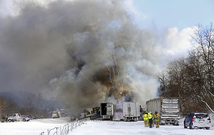 Emergency personnel watch as fireworks ignite at the scene of a fiery crash that closed both sides of Interstate 94, Friday, Jan. 9, 2015, between mile markers 88 and 92 in eastern Kalamazoo County, near Galesburg, Mich.
