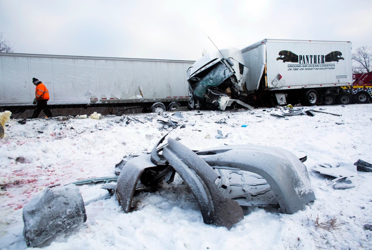 Road crews work to clear wrecked vehicles and debris along Interstate 94, Saturday, Jan. 10, 2015, the day after a series of crashes closed the highway between mile markers 88 and 92 in eastern Kalamazoo County, near Galesburg, Mich.