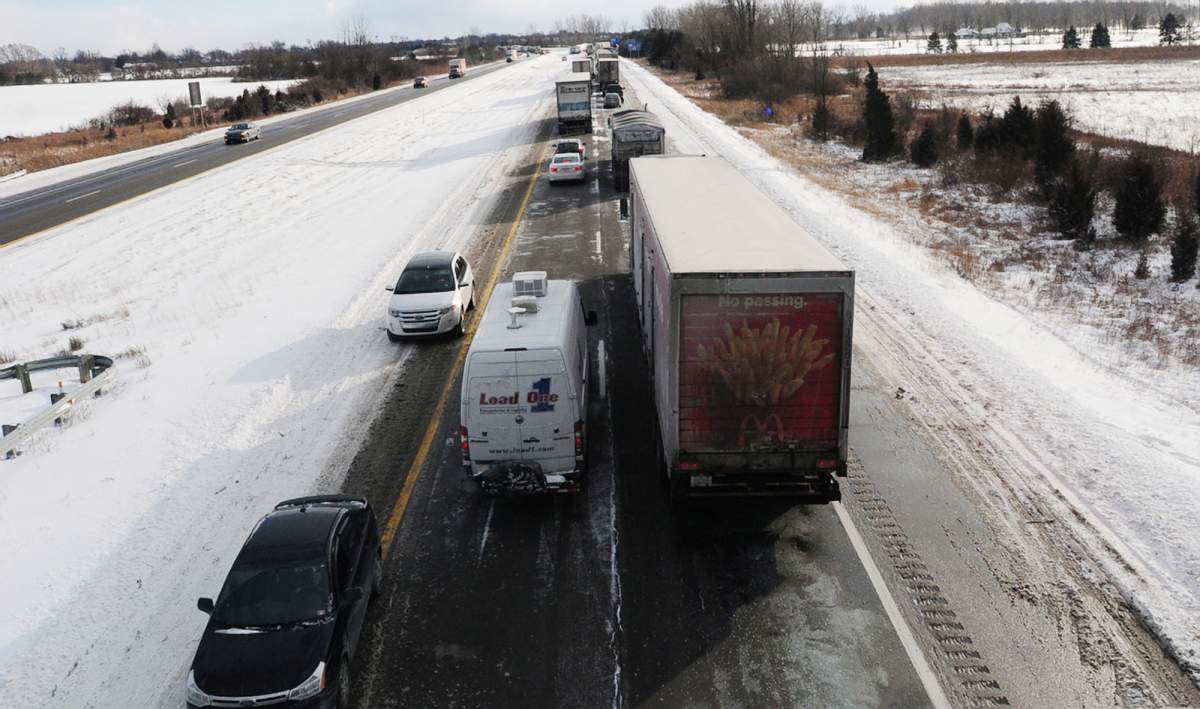 Cars begin to turn around on U.S. 23 after a massive pile up, in York Township, Mich. Friday, Jan. 9, 2015.