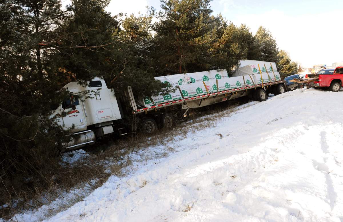 A semi truck comes to a stop in a ditch on U.S. 23 after a massive pile up in York Township, Mich. Friday, Jan. 9, 2015.