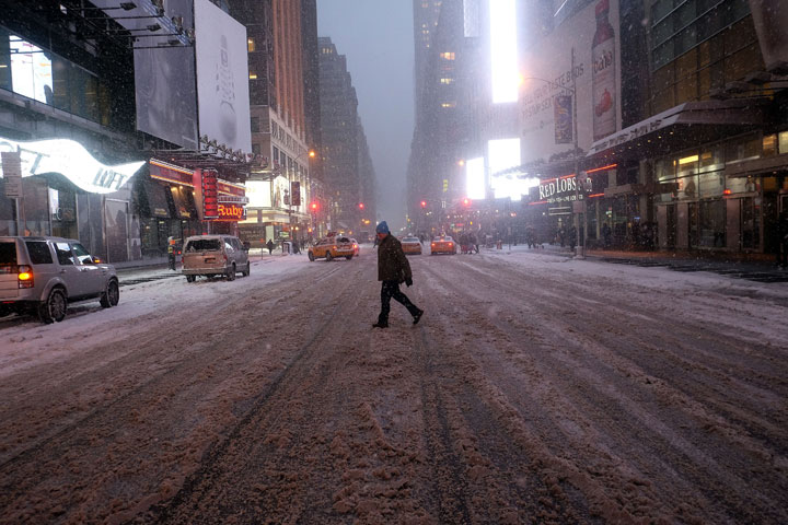 A man crosses a street in New York's Times Square during a snow storm on January 26, 2015. 