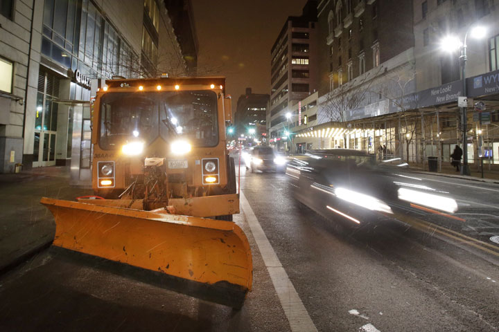 A New York City snowplow, loaded with salt, sits parked in midtown Manhattan as light snow falls, Monday, Jan. 26, 2015. 