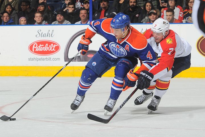 Taylor Hall #4 of the Edmonton Oilers skates with the puck while being pursued by Dmitry Kulikov #7 of the Florida Panthers on January 11, 2015 at Rexall Place in Edmonton, Alberta, Canada.