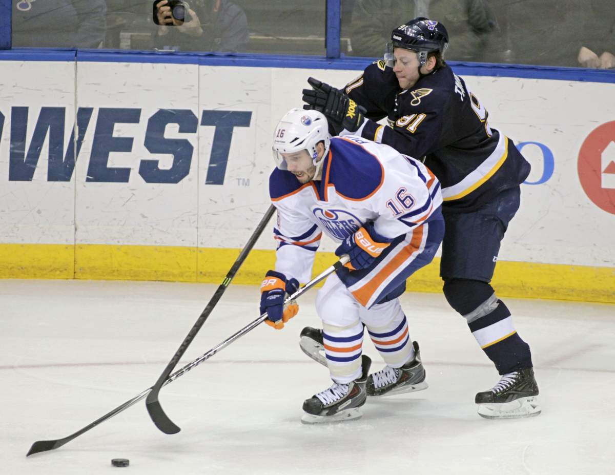 St. Louis Blues’ Vladimir Tarasenko (91) battles Edmonton Oilers’ Teddy Purcell (16) for the loose puck in the third period of a NHL hockey game, Tuesday, Jan. 13, 2015 in St. Louis. The Blues beat the Oilers 4-2.