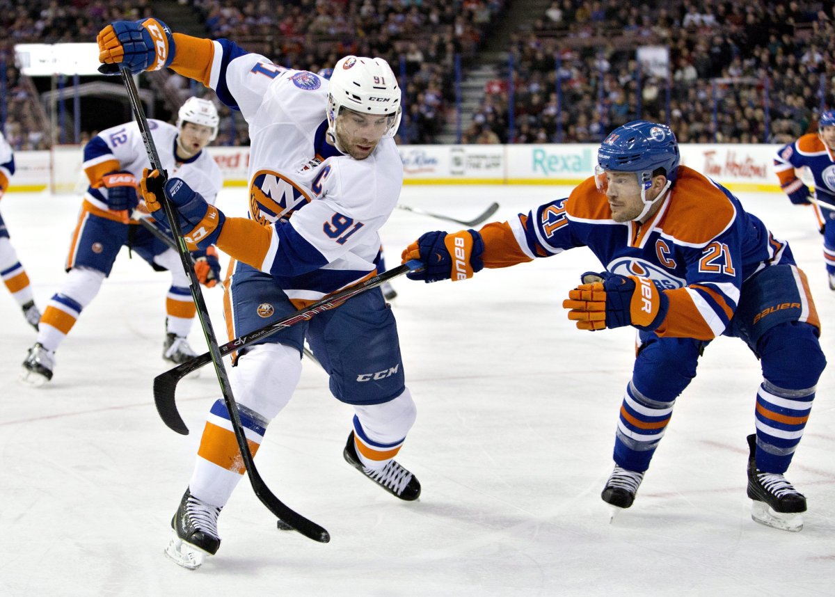 New York Islanders John Tavares (91) is chased by Edmonton Oilers Andrew Ference (21) during first period NHL hockey action in Edmonton, Alta., on Sunday January 4, 2015. 
