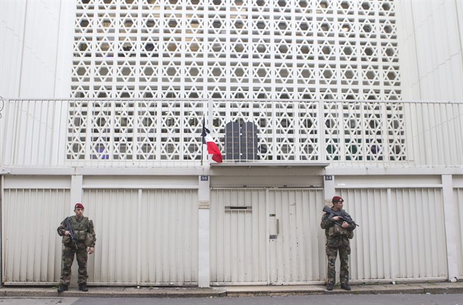 Soldiers stand guard outside a synagogue in Paris, Monday, Jan. 12, 2015. 