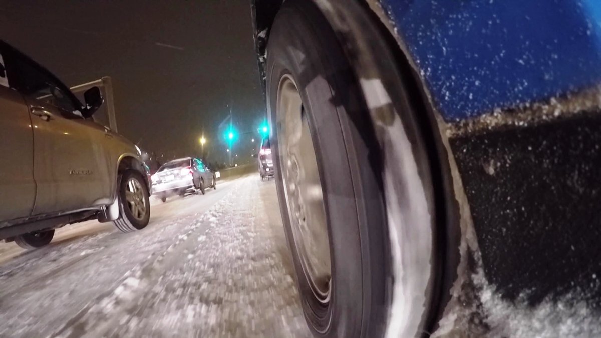 A vehicle drives along a snow-covered Calgary road.