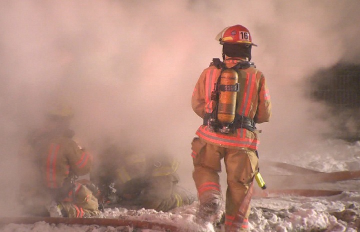 A Montreal firefighter battles a blaze on Papineau Street on January 9, 2015.