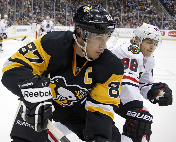 Pittsburgh Penguins' Sidney Crosby works the puck in the corner against Chicago Blackhawks' Patrick Kane during the second period of an NHL hockey game in Pittsburgh Wednesday, Jan. 21, 2015.