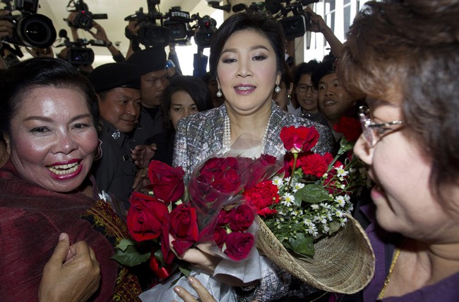 Thailand's former Prime Minister Yingluck Shinawatra, center, receives flowers from her supporters as she leaves parliament in Bangkok, Thailand, Thursday, Jan. 22, 2015. AP Photo/Sakchai Lalit).