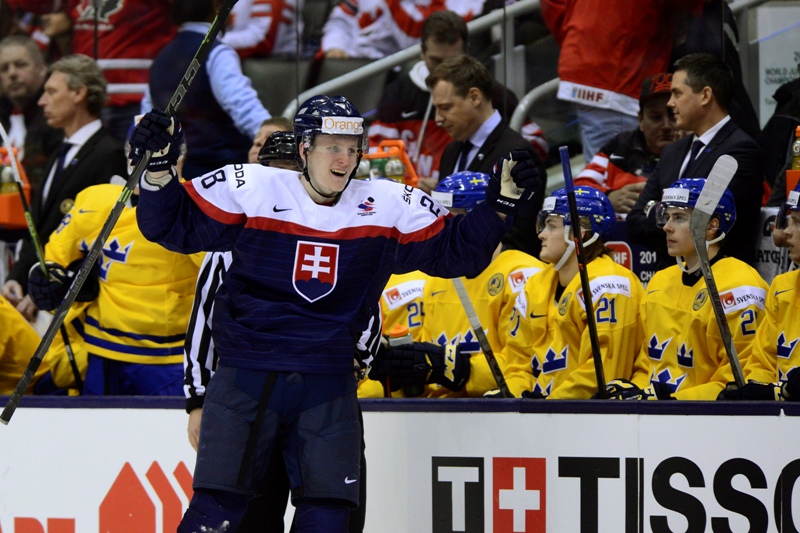 lovakia's Pavol Skalicky celebrates his third period goal in front of the Swedish bench during bronze medal game hockey action at the IIHF World Junior Championship in Toronto on Monday, Jan.5, 2015. 