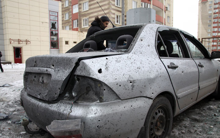 FILE- A man stands next to his car destroyed after shelling between Ukrainian army and pro-Russian separatists in the eastern Ukrainian city of Donetsk on January 18, 2015.