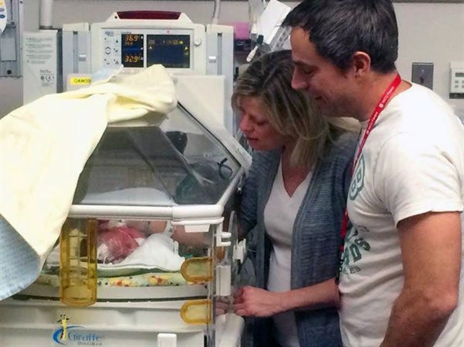 In this Jan. 1, 2015, photo Allison and Zach Peery check on their new son, Karl William Peery, in the neonatal intensive care unit at University Hospital in Salt Lake City. 