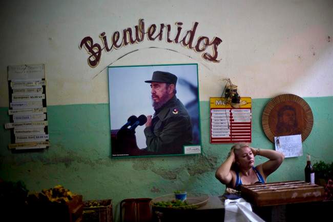In this Dec. 26, 2014 file photo, a photograph of Fidel Castro hangs under the Spanish word "Welcome" on the wall at a state-run food market in Havana, Cuba.