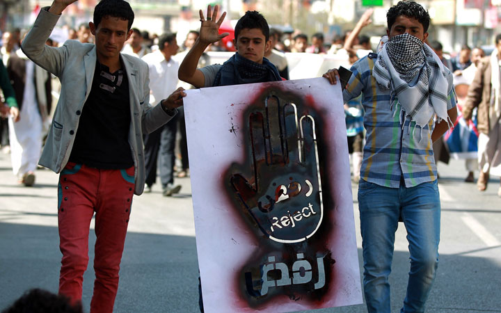 Yemeni protesters hold a banner during a demonstration against the presence of armed militias in the capital and also against attacks by Al-Qaeda, on January 17, 2015 in front of the Yemeni Defense Ministry in Sanaa.  