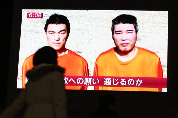 A TV news program shows two Japanese hostages, Kenji Goto, left, and Haruna Yukawa, held by the Islamic State group,  in Tokyo, Friday, Jan. 23, 2015.