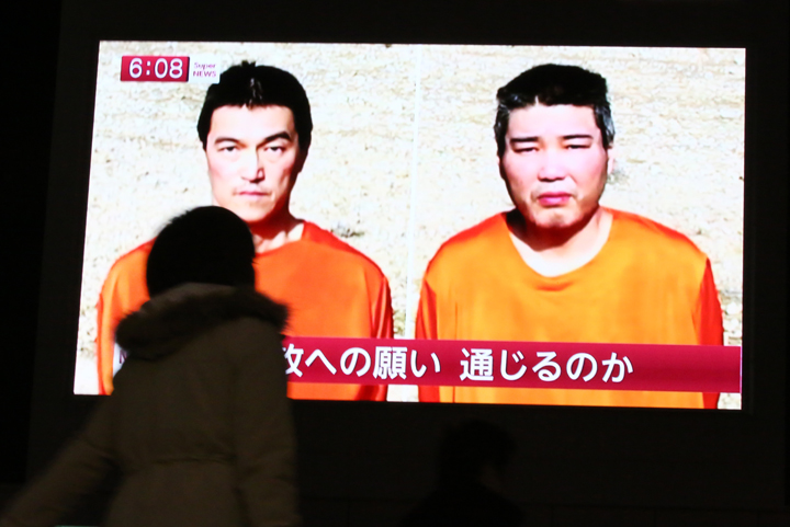 A TV news program shows two Japanese hostages, Kenji Goto, left, and Haruna Yukawa, held by the Islamic State group,  in Tokyo, Friday, Jan. 23, 2015.