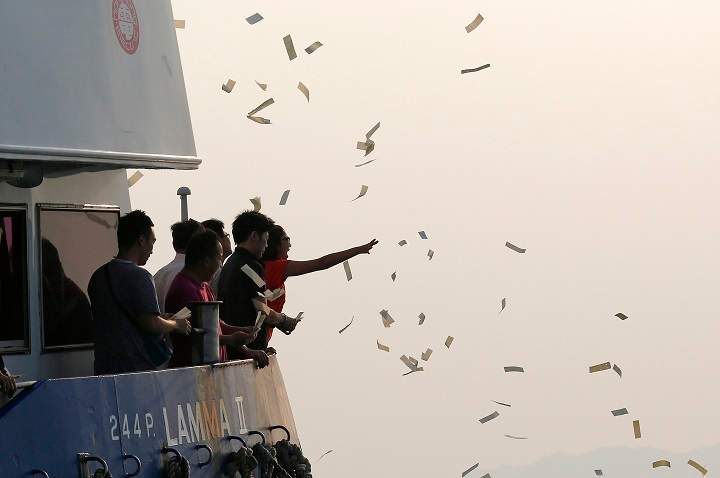 Relatives of victims throw paper money Tuesday, Oct. 2, 2012 as they pay tribute to the ill-fated people aboard a boat that sank near Lamma Island, off the southwestern coast of Hong Kong Island.