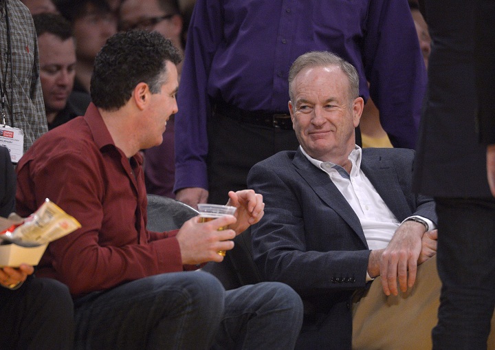 Television personality Bill O'Reilly, right, talks with actor Adam Carolla as they watch the Los Angeles Lakers play the Minnesota Timberwolves in an NBA basketball game, Thursday, Feb. 28, 2013, in Los Angeles.
