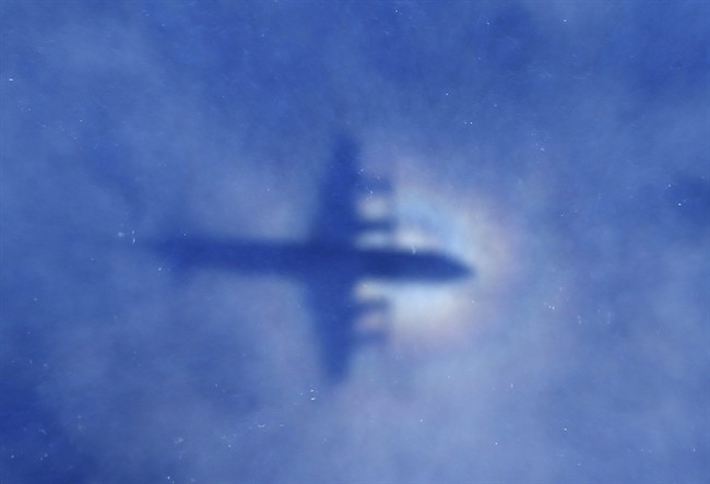 In this March 31, 2014 file photo, a shadow of a Royal New Zealand Air Force P-3 Orion aircraft is seen on low cloud cover while it searches for missing Malaysia Airlines Flight MH370 in the southern Indian Ocean. 