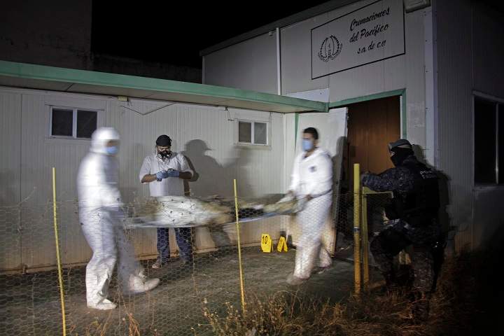 Forensic workers remove a body found at the crematorium of an abandoned funeral home near Acapulco, Mexico, early Friday Feb. 6, 2015.