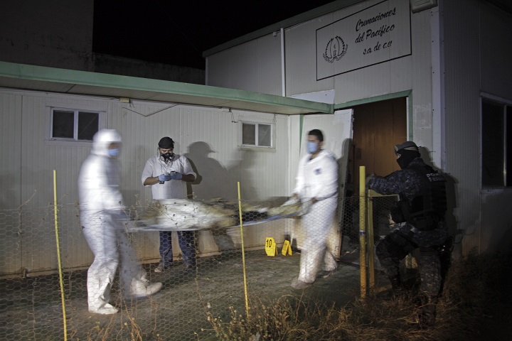 Forensic workers remove a body found at the crematorium of an abandoned funeral home near Acapulco, Mexico, early Friday Feb. 6, 2015.