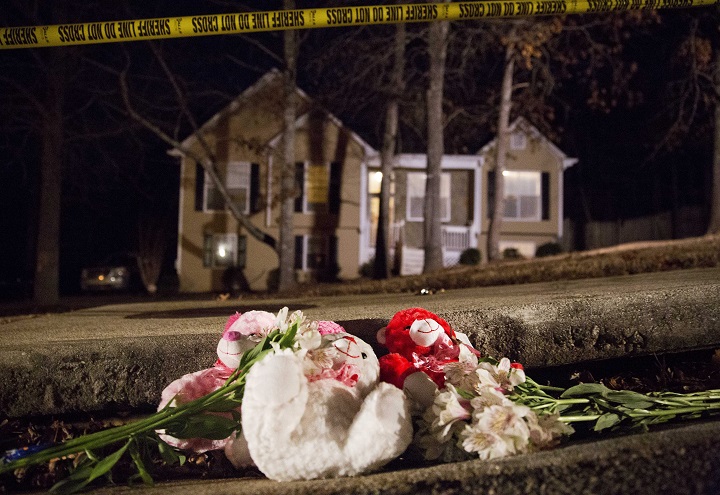 Flowers and teddy bears lay on the street outside the home of a shooting scene in Douglasville, Ga. on Saturday, Feb. 7, 2015. 