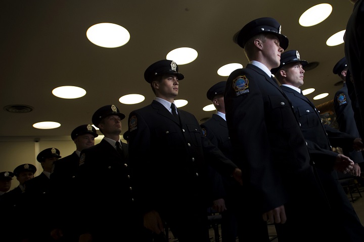 Firefighter graduates march in unison after receiving their badge and certificates during a graduation ceremony at the Toronto Fire/EMS Training Centre in Toronto on Thursday, July 31, 2014. 