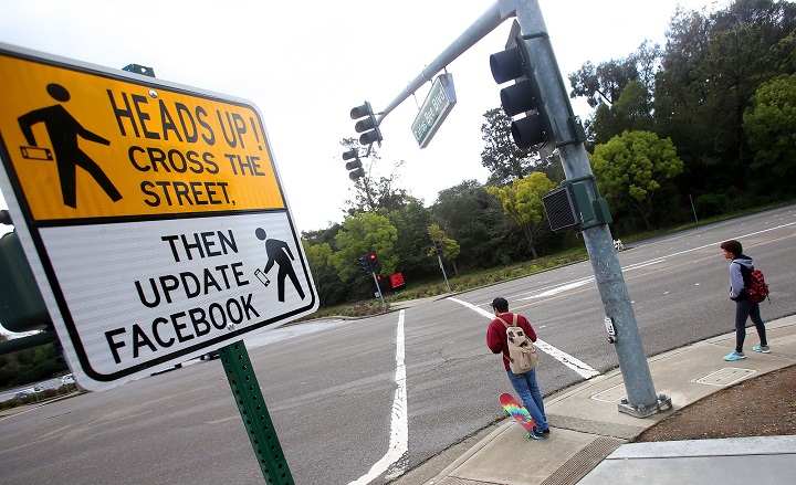 In this Feb. 9, 2015 photo, a new pedestrian crossing sign sits along Carlos Bee Boulevard in Hayward, Calif. The city is using humor to get drivers to slow down and pedestrians to pay attention.