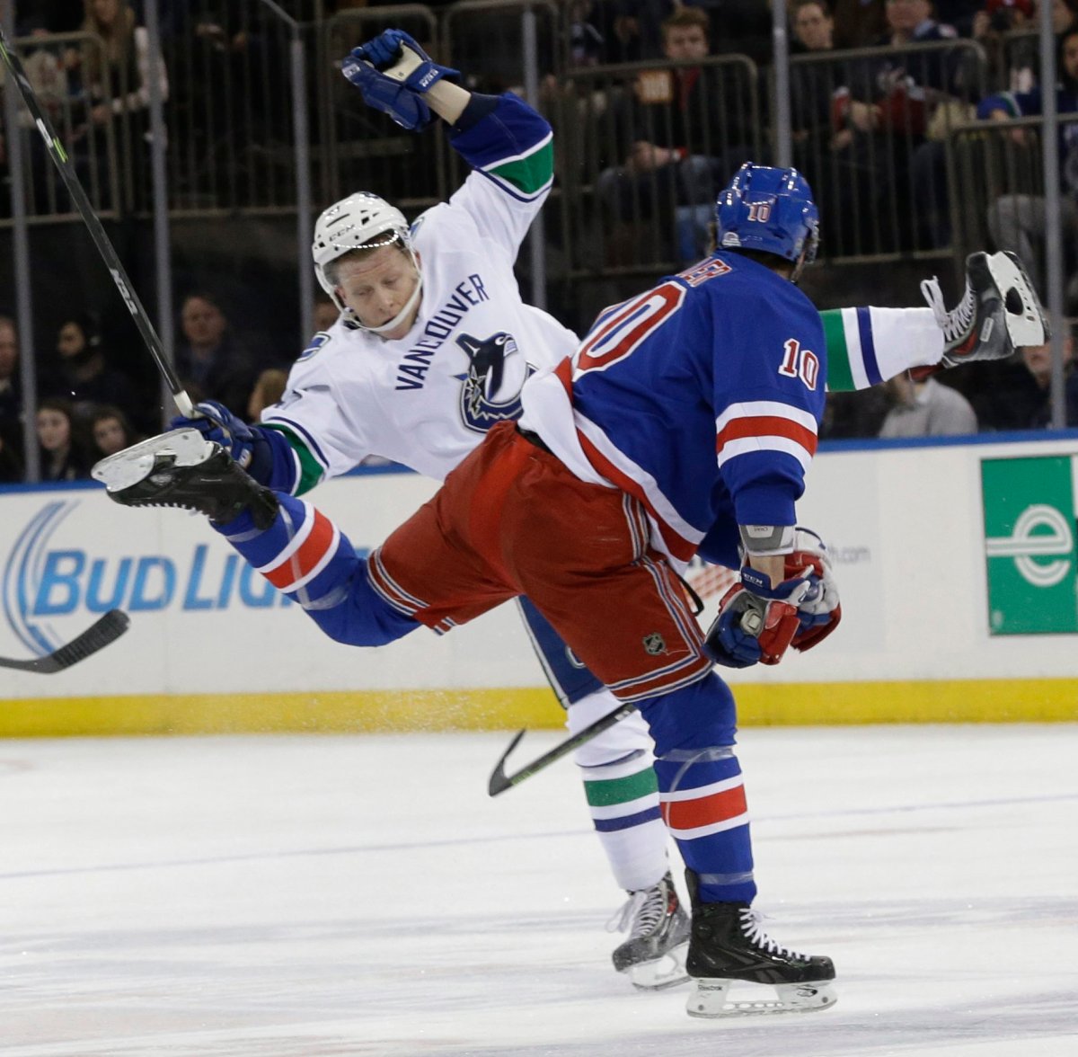 New York Rangers center J.T. Miller checks Vancouver Canucks left wing Ronalds Kenins during the first period.  