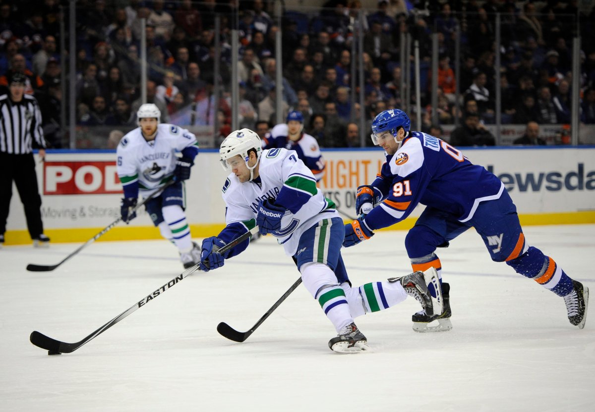 Vancouver Canucks right wing Linden Vey drives the puck down ice away from New York Islanders center John Tavares. 