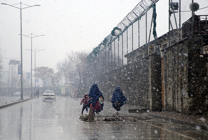 Burqa-clad Afghan women and a child walk during a snow storm in Kabul, Afghanistan, Tuesday, Feb. 24, 2015. 