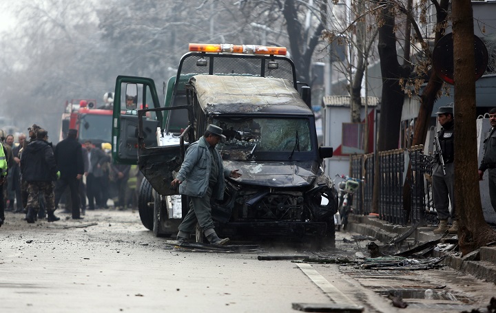Afghan security personal inspect a damaged vehicle at the site of a suicide attack in Kabul, Afghanistan, Thursday, Feb. 26, 2015. A suicide bomber driving a car packed with explosives targeted a Turkish Embassy vehicle near the Iranian Embassy in the Afghan capital during the Thursday morning rush hour.
