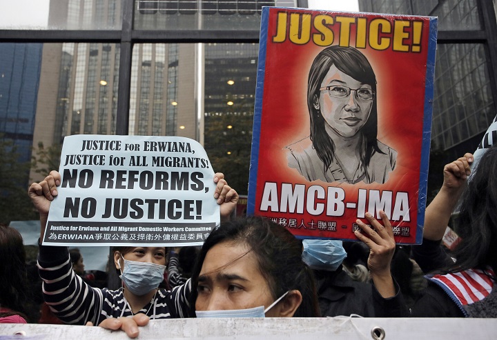 Supporters of Indonesian maid Erwiana Sulistyaningsih, hold placards as Sulistyaningsih arrives at a court in Hong Kong, Friday, Feb. 27, 2015.  A Hong Kong court sentenced a mother of two to six years in prison on Friday for abusing her Indonesian maid in a case that triggered outrage over its brutality. Law Wan-tung was found guilty earlier this month on 18 charges, including assault, grievous bodily harm, criminal intimidation and failure to pay wages or give time off work to  Sulistyaningsih.