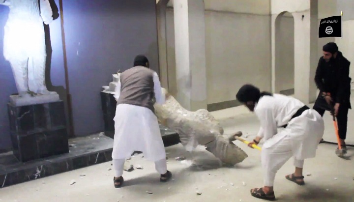 In this file image made from video posted on a social media account affiliated with the Islamic State group on Thursday, Feb. 26, 2015, which has been verified and is consistent with other AP reporting, militants take sledgehammers to an ancient artifact in the Ninevah Museum in Mosul, Iraq. 