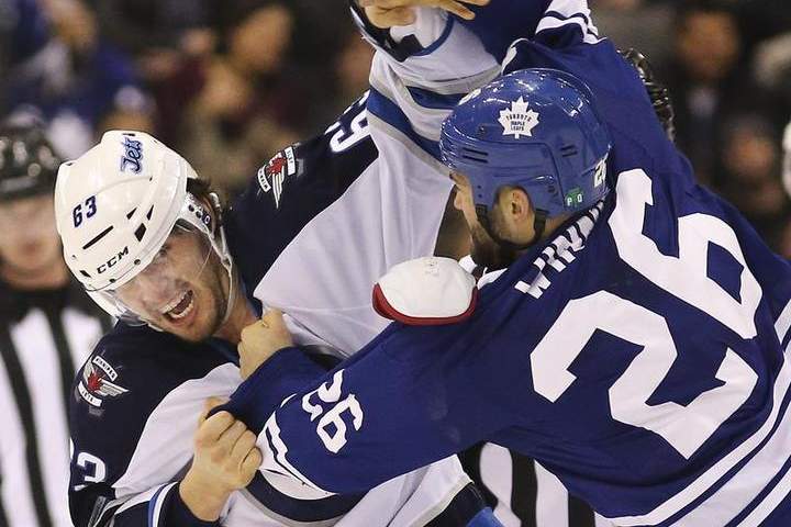 Daniel Winnik (26) of the Toronto Maple Leafs and Ben Chiarot (63) of the Winnipeg Jets scrap Saturday. Chiarot is out until early April with a left hand injury.