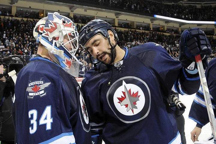 Winnipeg Jets Dustin Byfuglien (right) celebrates a victory with goaltender Michael Hutchinson at the MTS Centre.