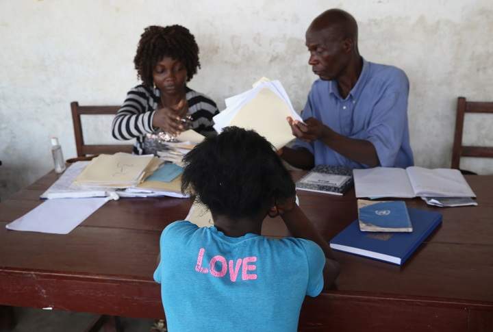 A mother sits to register her children with school officials on January 29, 2015 in the West Point township of Monrovia, Liberia.