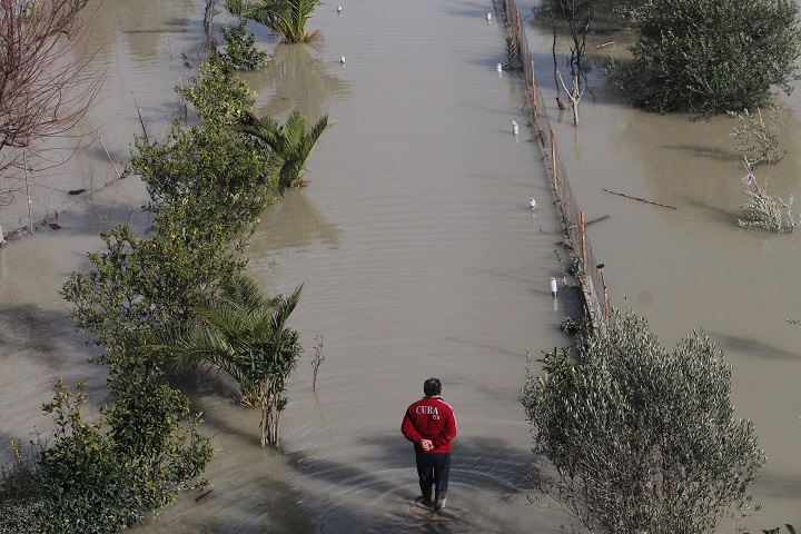 An Albanian man walks through water towards his home in the village of Mifol village near the city of Vlora on February 3, 2015. Floods caused by heavy rains over the last days have hit southern Albania, forcing the vacuation of hundreds of villagers after rivers flooded thousands of hectares (acres), hundreds of homes and many roads. 