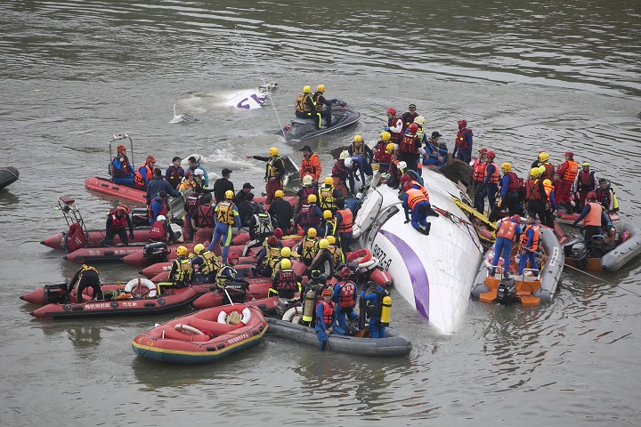 Rescue teams work to free people from a TransAsia Airways ATR 72-600 turboprop airplane that crashed into the Keelung River shortly after takeoff from Taipei Songshan airport on February 4, 2015 in Taipei, Taiwan.