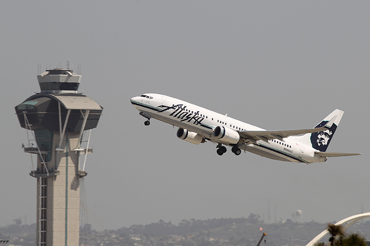 An Alaska Airlines jet passes the air traffic control tower at Los Angles International Airport (LAX) during take-off on April 22, 2013 in Los Angeles, California.