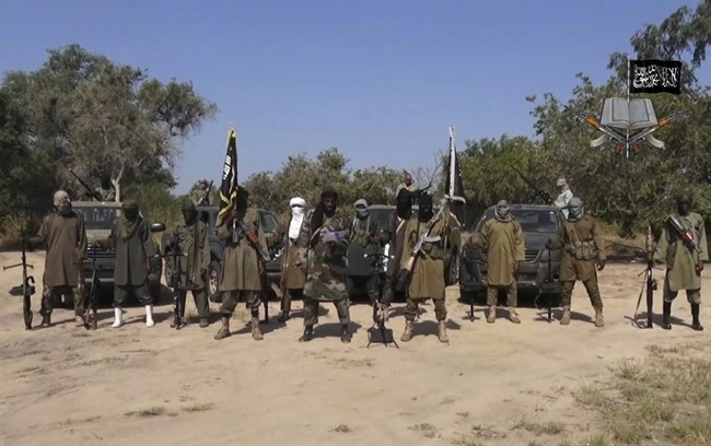 This file image taken from video released late Friday evening, Oct. 31, 2014 by Boko Haram, shows Abubakar Shekau, the leader of Nigeria's Islamic extremist group, at centre. 