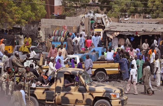 In this file photo taken Tuesday, Jan. 27, 2015, Nigerian soldiers, left, patrol a local market after recent violence in surrounding areas at Maiduguri, Nigeria.
