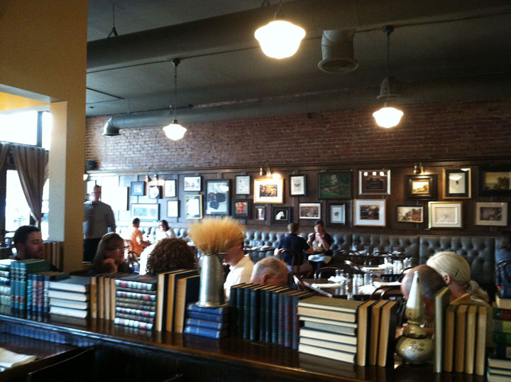 This Sept. 26, 2014 photo shows books along a room divider between the bar and restaurant in The Tavern in Tulsa, Okla. The books are arranged in such a way that they echo the colored geometric patterns found in the art deco architecture Tulsa is famous for. It's a technique that's easily adapted to home decor: arranging books by size and color in alternating vertical and horizontal stacks to create visual interest.