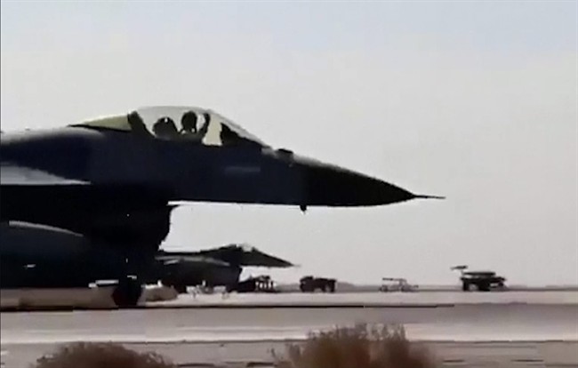 In this image made from Wednesday, Feb. 4, 2015, video provided by Jordanian military via Roya TV, an air force pilot raises his arm as he taxis his jet at Mowafak Al-Salti airbase in Azraq, Jordan. 