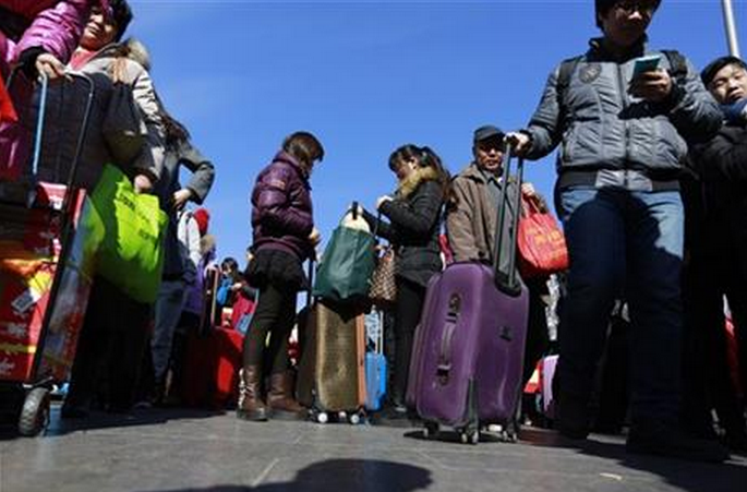 Chinese traveler queue up at the main entrance to the Beijing railway station in Beijing, Tuesday, Feb. 17, 2015. Millions of Chinese are traveling to their hometowns to celebrate the Lunar New Year on Feb. 19 this year which marks the Year of the Sheep on the Chinese zodiac. 