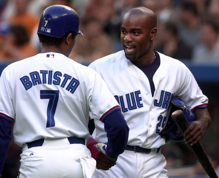 Toronto Blue Jays Tony Batista (left) congratulates teammate Carlos Delgado as he comes in on a Brad Fullmer double against the Tampa Bay Devil Rays during first inning action in Toronto, Ont. on Wednesday, July 19, 2000. 