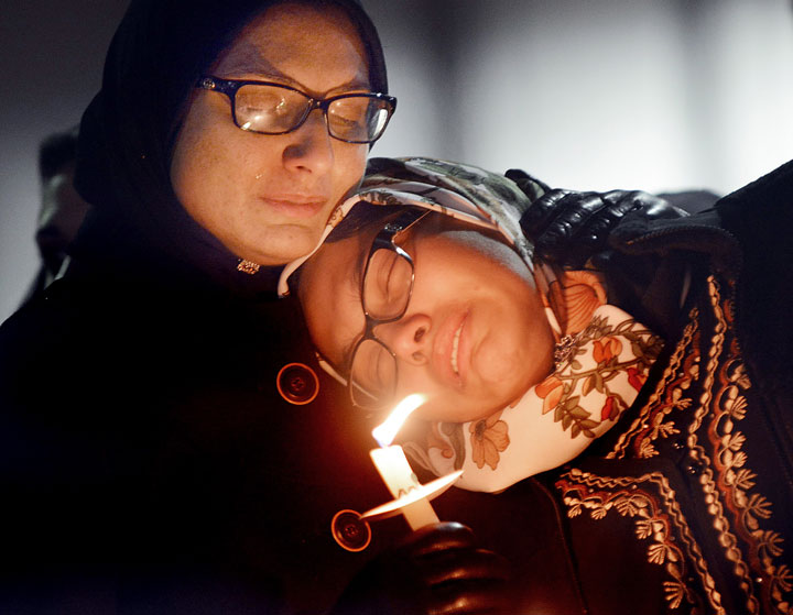 Women mourn during a vigil for three people who were killed at a condominium near UNC-Chapel Hill, Wednesday, Feb. 11, 2015, in Chapel Hill, N.C. 